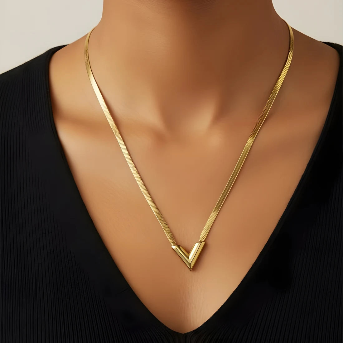 Gold necklace on a mannequin with a plain background
