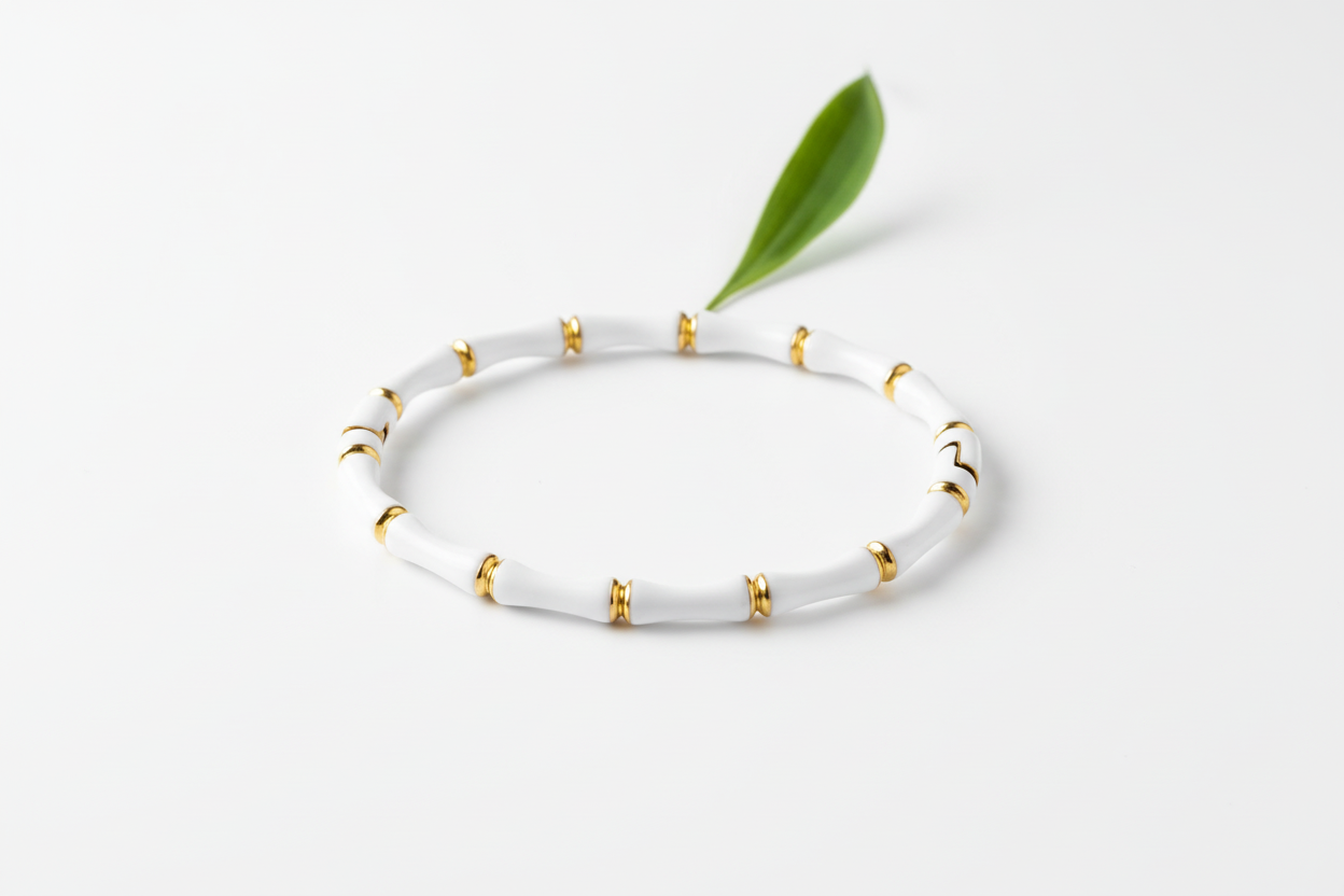 White bracelet with gold accents on a wooden surface