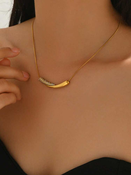 Gold necklace with a unique design worn by a person