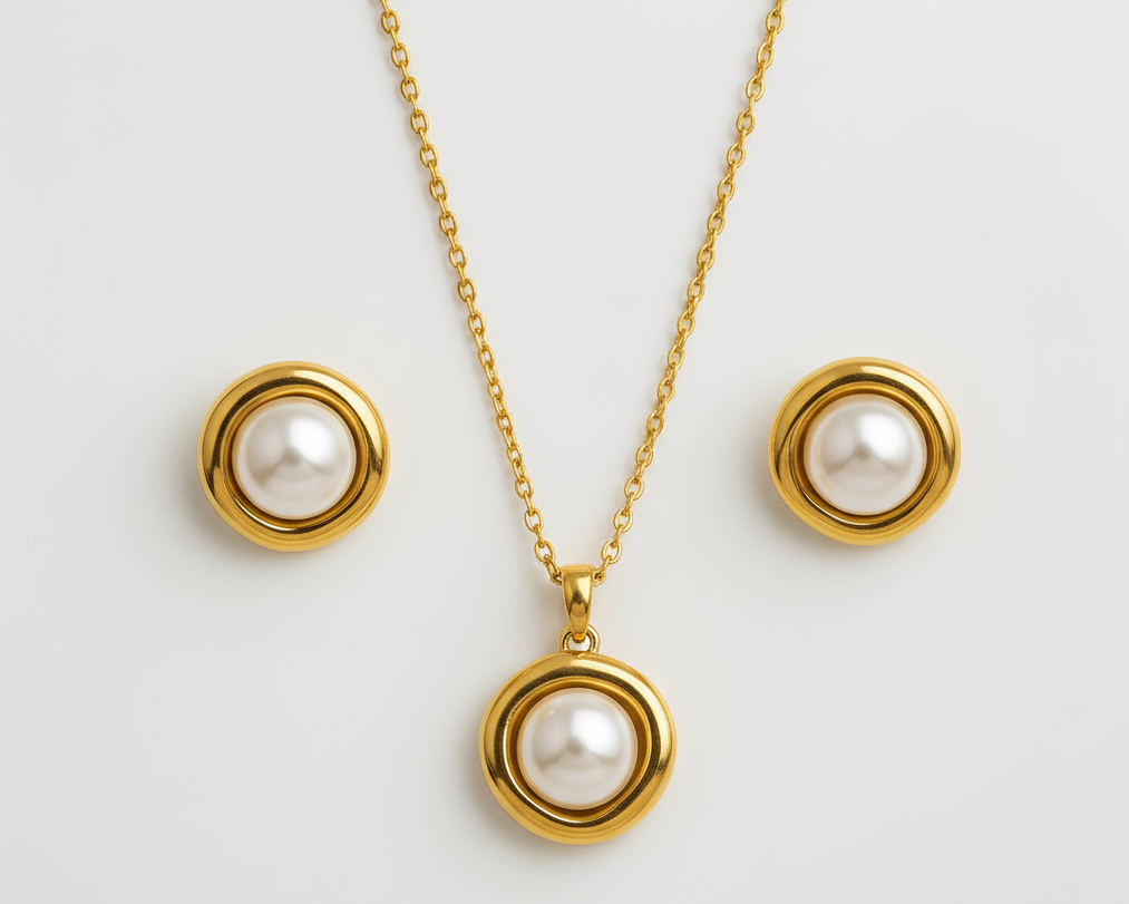 Gold necklace and earrings with pearl pendants on a white  background