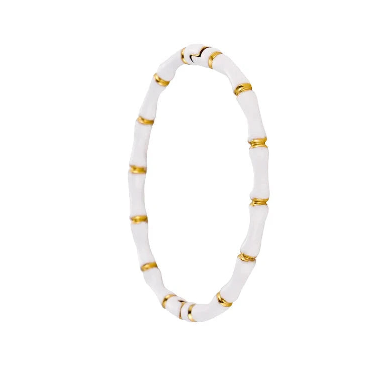 White bracelet with gold accents on a white background